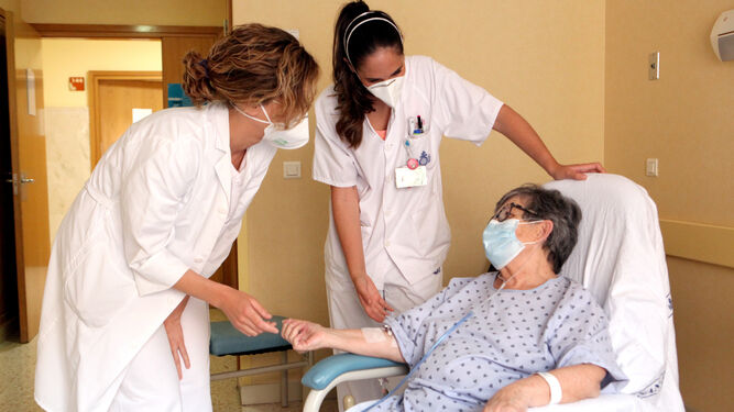 La internista Rocío Fernández Ojeda, a la izquierda, visita a una paciente hospitalizada en el área de Medicina del centro.