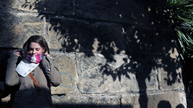 Una joven se coloca la bufanda en una calle de Sevilla