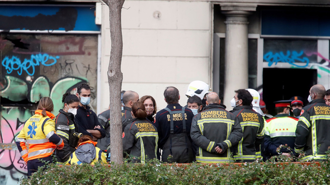 La alcaldesa de Barcelona, Ada Colau, atiende a las explicaciones de los bomberos.