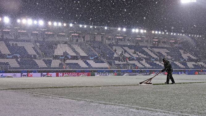 Trabajadores del club intentan retirar la nieve del Gewiss Stadium.