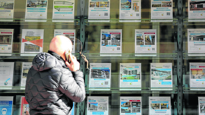 Una persona habla por telefóno mientras mira las ofertas de una agencia inmobiliaria, el pasado febrero, en Málaga.