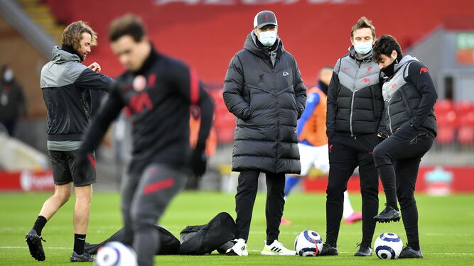 El cuerpo técnico del Liverpool, con mascarilla en un entrenamiento en Anfield.