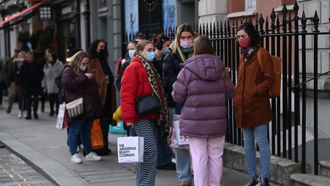 Un grupo de mujeres llevan mascarillas por las calles de Londres