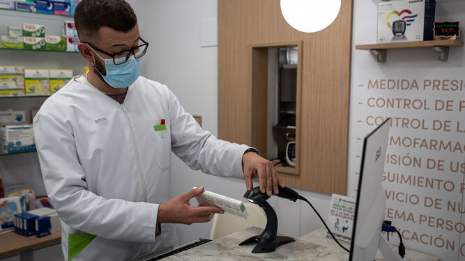 Un farmacéutico procediendo a la venta de un test de antígenos