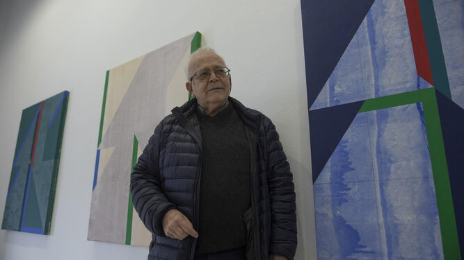 Gerardo Delgado ante los tres cuadros verticales que destacan en la sala principal.