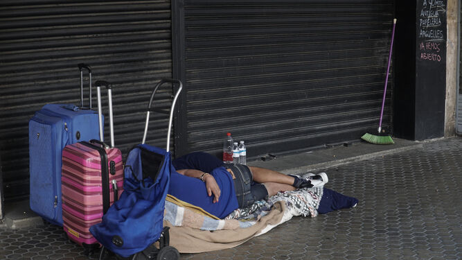 Una persona sin hogar durmiendo en una calle del centro de Sevilla.
