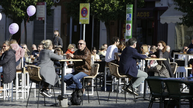 Un grupo de personas disfruta al sol en una terraza en Sevilla.