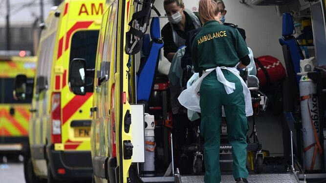 Dos sanitarios bajan a un paciente de la ambulancia en Londres