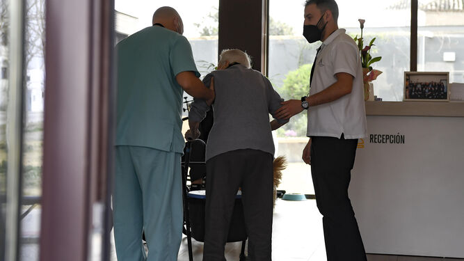Personal sanitario acompaña a una persona mayor residente en un geriátrico andaluz.