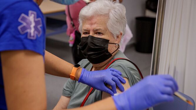 Una mujer recibe la tercera dosis de la vacuna contra el Covid -19 en el Distrito Sanitario de Sevilla.