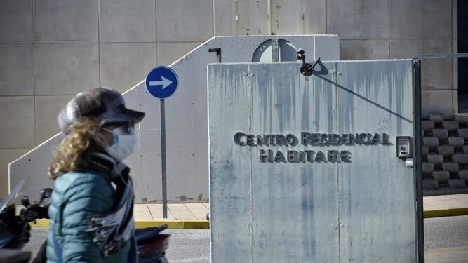 Una mujer pasa por delante del centro residencial Habitare en Castilleja de la Cuesta con un brote de Covid.