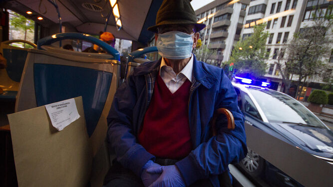 En el autobús con mascarilla quirúrgica.