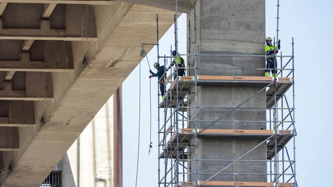 Operarios de la UTE adjudicataria montando andamios para recrecer la estructura del puente.