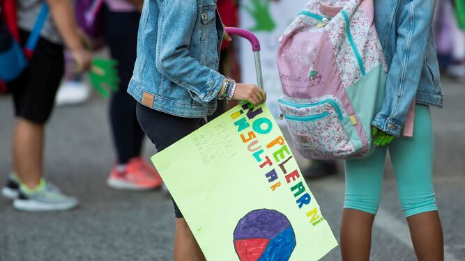 Una niña porta una pancarta contra la violencia en las aulas.