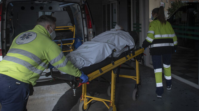 Personal sanitario traslada a un enfermos en camilla en las Urgencias del Virgen del Rocío.