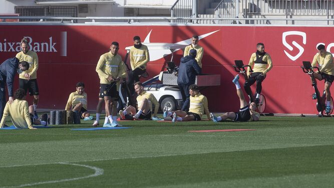 Los jugadores del Sevilla hacen trabajo preventivo por postas.