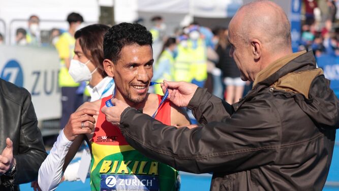 Antonio Muñoz le pone la medalla a Lamdassem tras su récord.