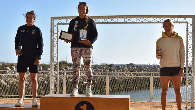Pilar Lamadrid sonríe en lo más alto del podio tras su título en iQFoil en la Semana Olímpica Andaluza.