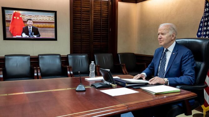Fotografía cedida por la Casa Blanca donde aparece el presidente de Estados Unidos, Joe Biden (d), mientras habla con su homólogo chino, Xi Jinping (en pantalla), durante su reunión virtual.