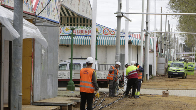 Operarios colocando las bombillas en real de la Feria.
