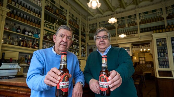 Javier y Carlos De Rueda, propietarios de El Rinconcillo, muestran la edición limitada de Cruzcampo con motivo de los 350 años del bar.