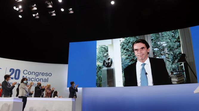 Los asistentes al 20º Congreso Nacional del PP aplaude a José María Aznar, conectado por videoconferencia.