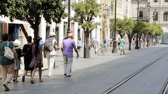 Turistas pasean por la Avenida de la Constitución.