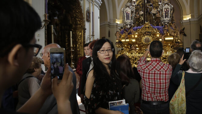 Una turista asiática se hace una fotografía  ante Jesús Nazareno en la iglesia de San Antonio Abad.