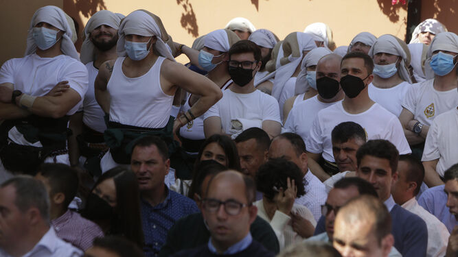 El público sin mascarilla en la salida de La Milagrosa de Ciudad Jardín, con una cuadrilla de costaleros al fondo, todos con mascarillas.