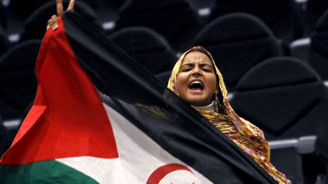 Una mujer con una bandera saharaui.