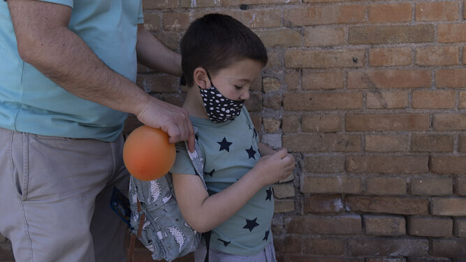 Un pequeño con su mascarilla a las puertas de un colegio en Sevilla.