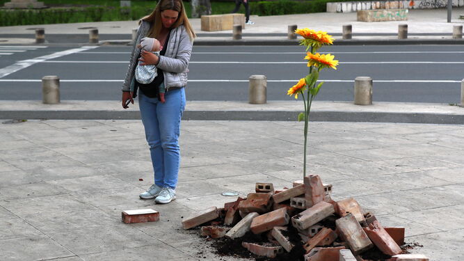 Una madre observa un homenaje a los caídos de Ucrania en una calle de Bucarest (Rumanía).