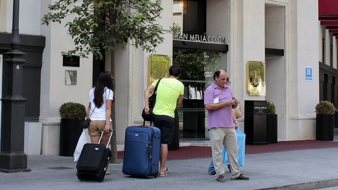 Imagen de archivo de turistas en la puerta del Hotel Colón de Sevilla.