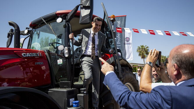 El presidente de la Junta, Juanma Moreno, baja de un tractor el viernes en la asamblea de Asaje en Antequera.