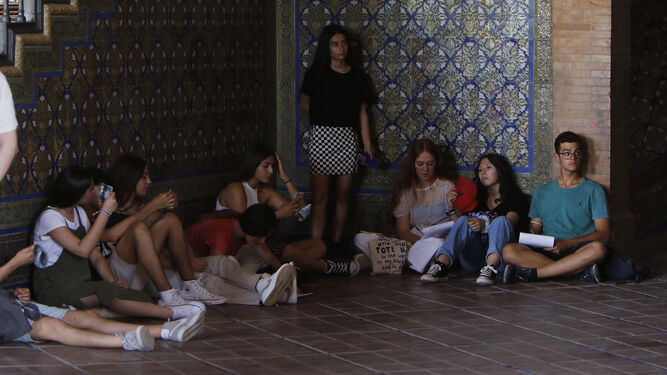 Un grupo de jóvenes refugiándose de sol en la Plaza de España.