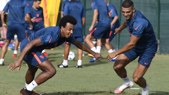 Koundé y Diego Carlos inician sonrientes un sprint en un entrenamiento.
