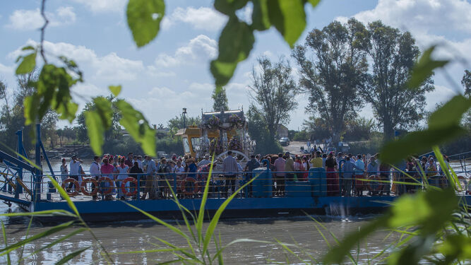 La Hermandad de Fuengirola atraviesa en barcaza el río Guadalquivir.