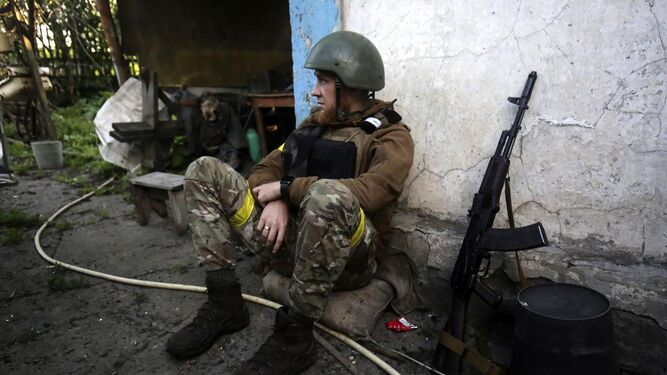 Un soldado descansa apoyado en un muro
