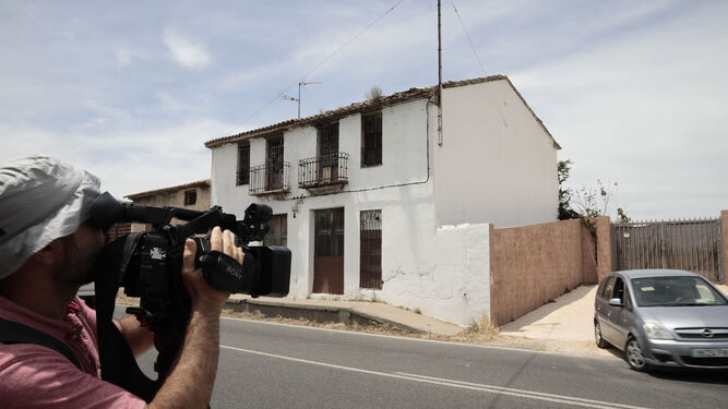 Un cámara y un fotógrafo toman imágenes de la vivienda en la que se localizó el cuerpo en Alcira.