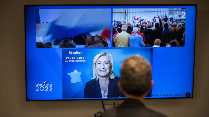 Un periodista observa en una pantalla el discurso de Marine Le Pen tras conocerse los resultados de la segunda vuelta.