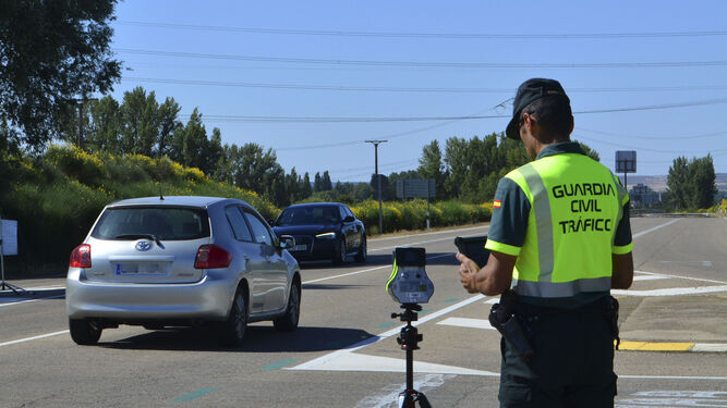 Un agente de la Guardia Civil maneja un radar en la carretera CL-615 (Palencia-Guardo), para controlar la velocidad de los vehículos.