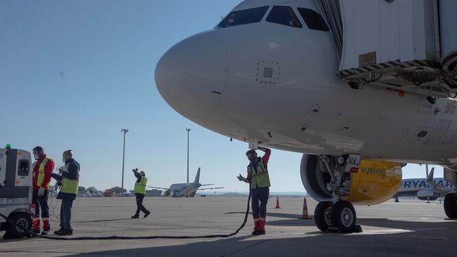Operarios preparan en Sevilla el avión del primer vuelo verde de Vueling en la ruta Barcelona-Sevilla.