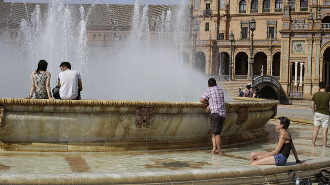 Turistas dentro de la fuente de la Plaza de España la semana pasada durante la anterior ola de calor.