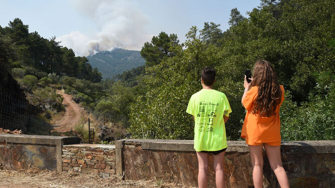 Dos personas observan el incendio de la comarca de Las Hurdes, en Cáceres.