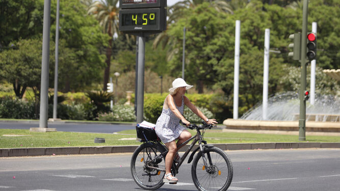 Una mujer en bicicleta por una céntrica calle de la ciudad el pasado fin de semana cuando el termómetro marcaba 45 grados.