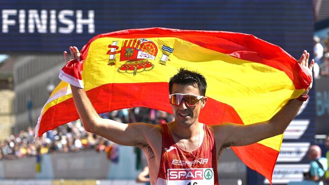 Miguel Ángel López en la meta como campeón con la bandera española.