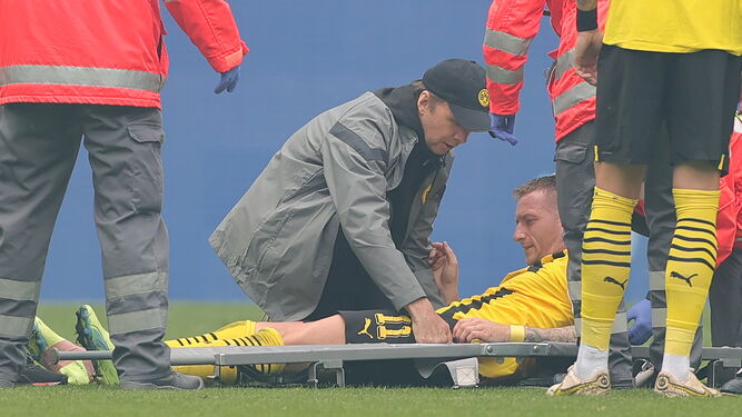Marco Reus es atendido antes de ser trasladado en camilla tras torcerse el tobillo derecho.