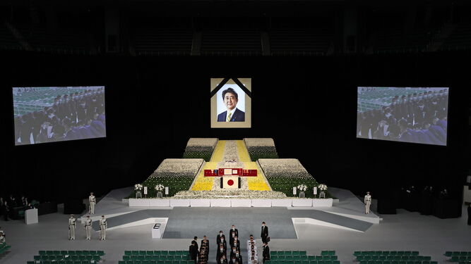 La viuda del ex primer ministro japonés Shinzo Abe (en las pantallas) porta sus cenizas en el funeral de Estado.