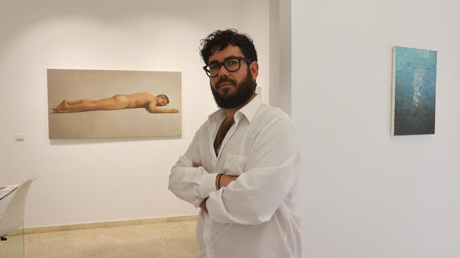 Guillermo Amaya Brenes, codirector de la galería Domo, posa ante las obras de Juan Manuel Rodríguez.