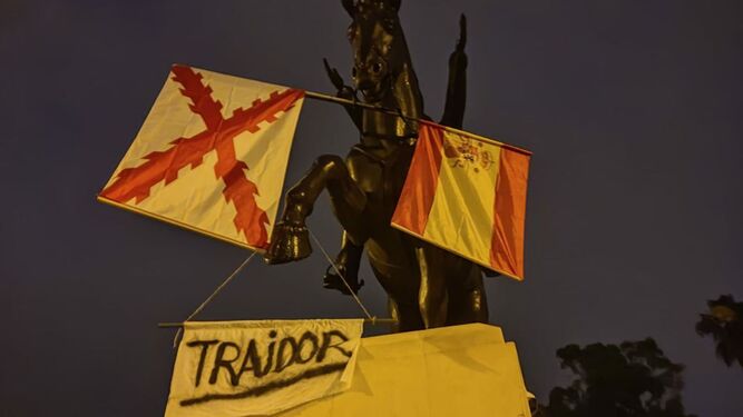 La estatua de Simón Bolívar, con las banderas y la pancarta con la que ha amanecido este 12 de octubre.